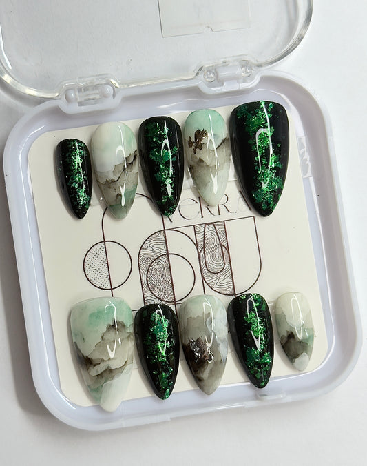 Set of green and white marbled nail art designs in a clear case.